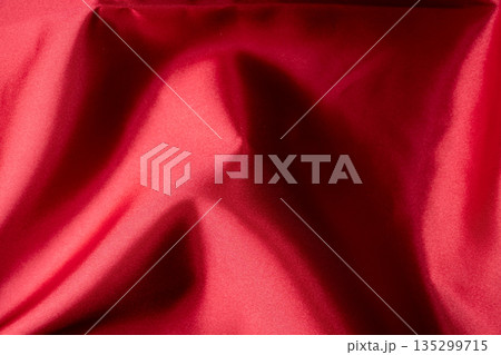 赤い布の光沢と陰影を捉えたテクスチャー素材 135299715