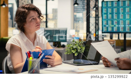 Human resources recruiter evaluating a confident male candidate during a professional job search conversation about employment and onboarding within a growing enterprise. Head hunting. Camera B. Human resources recruiter evaluating a confident male candidate during a professional job search conversation about employment and onboarding within a growing enterprise. Head hunting. Camera B. 135299922
