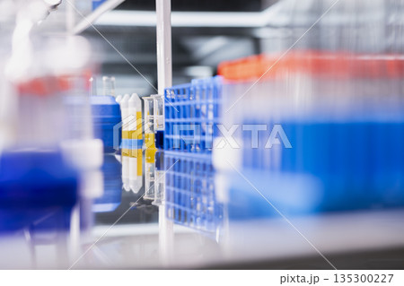 Close up of reagents in vials ready to be used for experimental analysis inside modern research center. Colorful chemical solutions inside test tubes rack on laboratory shelf 135300227