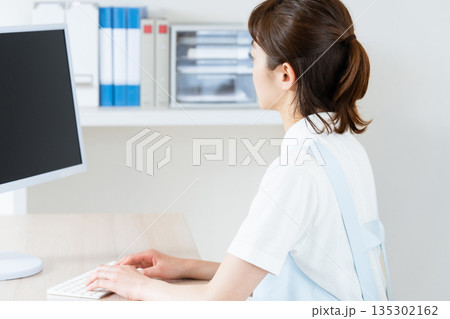 事務作業をするエッセンシャルワーカーの女性 135302162