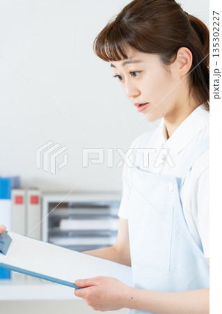 事務作業をするエッセンシャルワーカーの女性 135302227