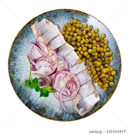 Herring with chopped onion and green peas on a round plate 135303477