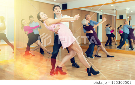 Young girl learning to dance waltz with guy in dancing class Young girl learning to dance waltz with guy in dancing class 135303505