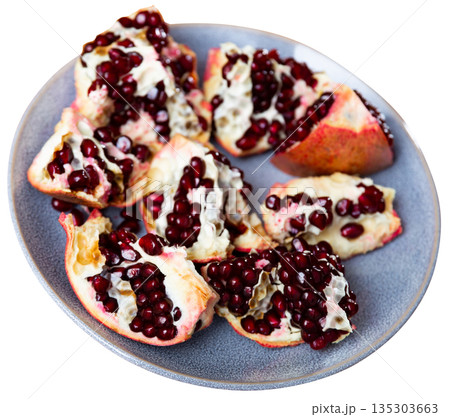Pieces of ripe pomegranate on a plate top view 135303663