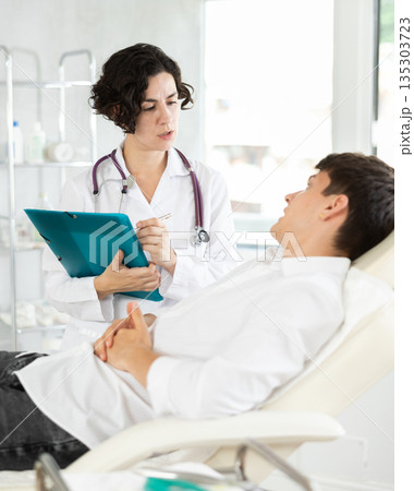 Female doctor communicates with male patients in cosmetology clinic before surgery 135303723
