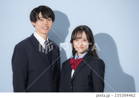 水色背景で並んで立つ高校生の男女　女子高生と男子高生の2人のカメラ目線の上半身 135304462