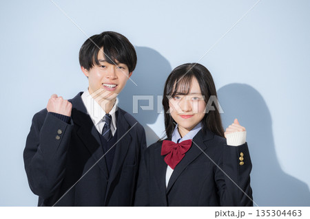 水色背景で並んで立つ高校生の男女 女子高生と男子高生の2人のカメラ目線の上半身ガッツポーズ 水色背景で並んで立つ高校生の男女 女子高生と男子高生の2人のカメラ目線の上半身ガッツポーズ 135304463