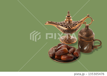 Decorative setup showcasing Arabic coffee pot with dates on plate Decorative setup showcasing Arabic coffee pot with dates on plate 135305476