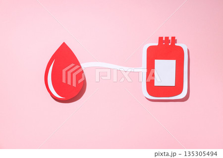 Paper cutout of a blood droplet and blood bag on pink background 135305494