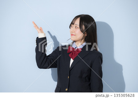 水色背景で女子高生の上半身のオススメの紹介ポーズ 水色背景で女子高生の上半身のオススメの紹介ポーズ 135305628