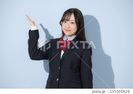 水色背景で女子高生のカメラ目線の上半身のオススメの紹介ポーズ 水色背景で女子高生のカメラ目線の上半身のオススメの紹介ポーズ 135305629