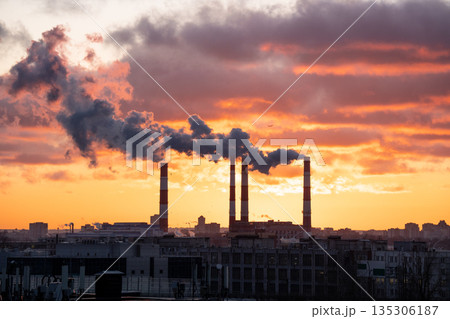 Smoke from factory pipe of heat station in city in winter. Fuel oil or natural gas-fired power plant 135306187