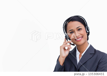 Asian woman standing in studio against white backdrop, wearing gray blazer and headset, copy space 135306431
