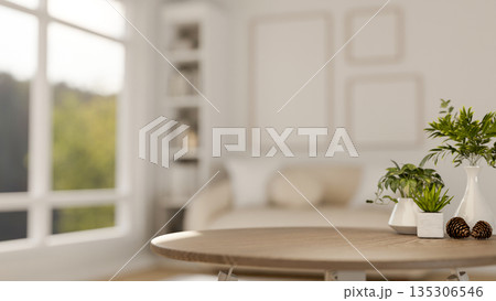 Decorative acorns with vase and green pot plants on wooden table in a white living room with sofa. 135306546