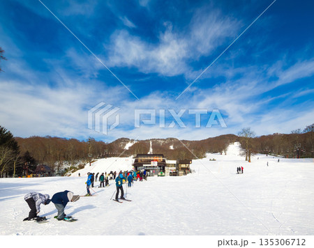 スキー場のリフト乗り場前で滑走準備をする人々と行列が見える風景 (群馬県、沼田市、たんばら) 135306712
