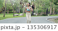 Young runner Asian woman jogging in park path, skinny fit in sports wear outfit leggings and top 135306917