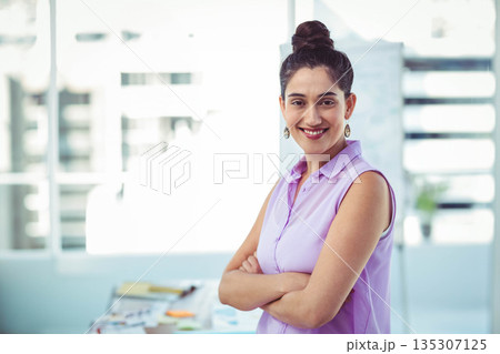 South Asian woman smiling, crossing arms at office desk with papers and sticky notes, copy space South Asian woman smiling, crossing arms at office desk with papers and sticky notes, copy space 135307125