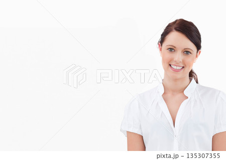Woman in white blouse standing against white backdrop on right side, smiling and posing, copy space Woman in white blouse standing against white backdrop on right side, smiling and posing, copy space 135307355