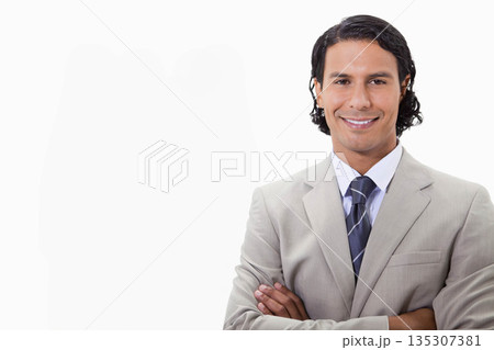 Man standing with arms crossed in studio wearing gray suit striped tie, copy space Man standing with arms crossed in studio wearing gray suit striped tie, copy space 135307381