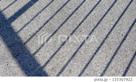 アスファルトに落ちた柵の影 135307922