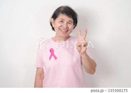 Elderly woman with pink Ribbon for Pink October Breast Cancer Awareness month, May Women Health, February World cancer day, support people life and illness. National cancer survivors month Elderly woman with pink Ribbon for Pink October Breast Cancer Awareness month, May Women Health, February World cancer day, support people life and illness. National cancer survivors month 135308175
