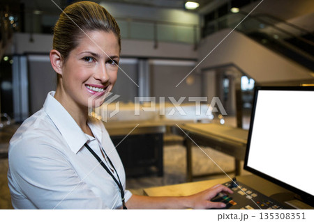 Female staff member operating control panel beside monitor at banquet buffet station, copy space Female staff member operating control panel beside monitor at banquet buffet station, copy space 135308351