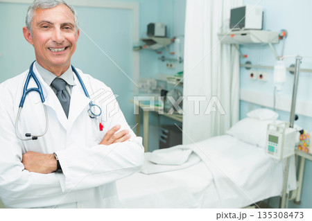 Senior male doctor standing with lab coat and stethoscope in hospital room, copy space Senior male doctor standing with lab coat and stethoscope in hospital room, copy space 135308473