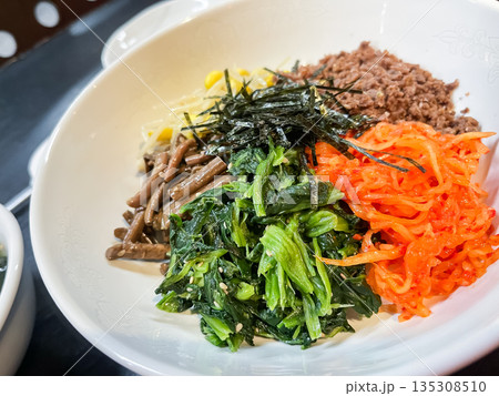 韓国料理のビビンバ。人参とほうれん草のナムル、ひき肉を乗せたご飯。 韓国料理のビビンバ。人参とほうれん草のナムル、ひき肉を乗せたご飯。 135308510
