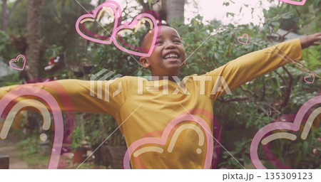 Smiling boy raising arms and lifting chin in backyard garden, with heart and rainbow overlays Smiling boy raising arms and lifting chin in backyard garden, with heart and rainbow overlays 135309123