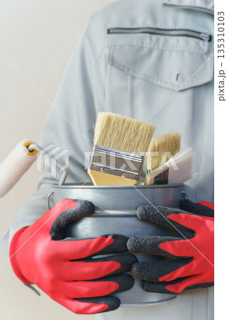 刷毛やローラーの入ったバケツを持つ作業服の人｜リフォーム・塗装業者・DIY　イメージ 135310103