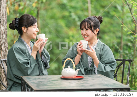 旅先で森林浴をしながらお茶を飲む浴衣姿の若いアジア人女性 旅先で森林浴をしながらお茶を飲む浴衣姿の若いアジア人女性 135310157