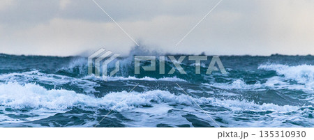 雪が舞い白波が立つ冬の日本海の寒々しい風景 135310930