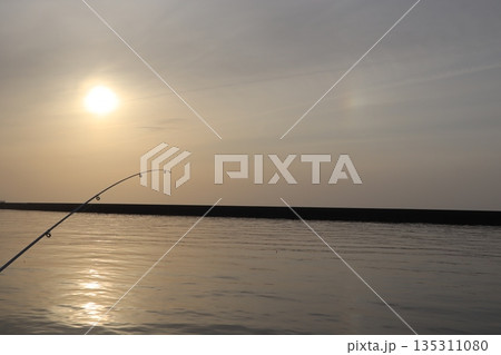 夕日と虹に染まる釣り竿 135311080