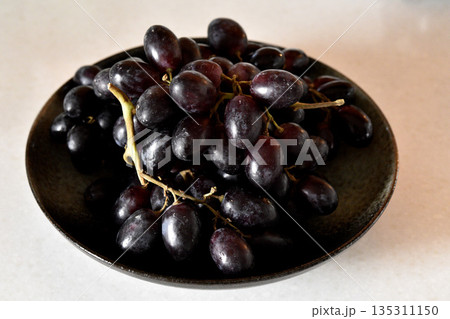 Black grape on black plate. 135311150