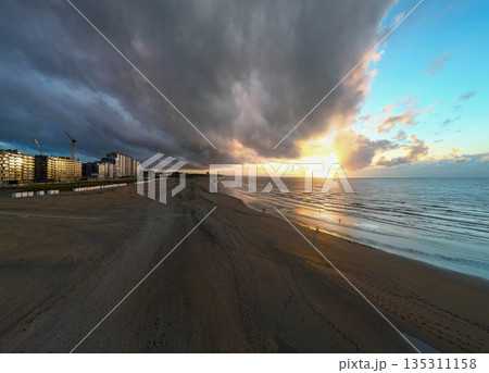 Savoring the Peace and Beauty of a Serene Coastal Sunset Over a Tranquil Beachscape 135311158