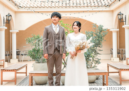 結婚式場のガーデンでガーデンウェディングをする新郎新婦（ブライダル・ウェディング） 135311902