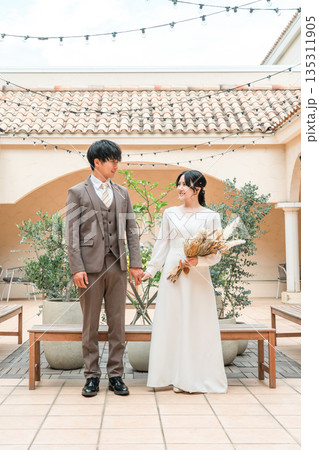結婚式場のガーデンでガーデンウェディングをする新郎新婦(ブライダル・ウェディング) 結婚式場のガーデンでガーデンウェディングをする新郎新婦(ブライダル・ウェディング) 135311905