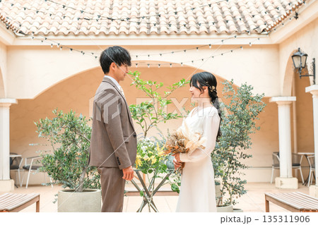 ブーケを持って見つめ合う新郎新婦(ウェディング・ブライダル・夫婦) ブーケを持って見つめ合う新郎新婦(ウェディング・ブライダル・夫婦) 135311906
