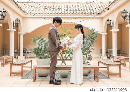 ブーケを持って見つめ合う新郎新婦(ウェディング・ブライダル・夫婦) ブーケを持って見つめ合う新郎新婦(ウェディング・ブライダル・夫婦) 135311908