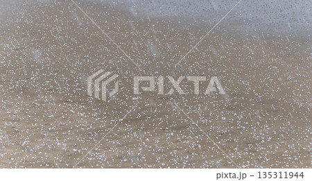 冬の山陰地方にある砂浜パラパラと突然降ってきた霰 135311944
