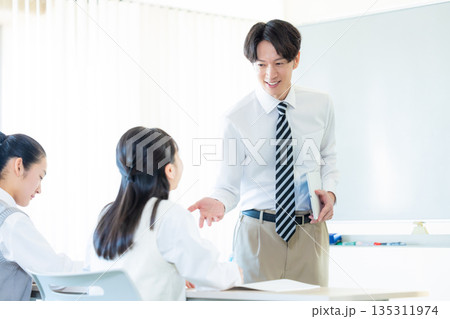 塾で勉強する学生と講師 塾で勉強する学生と講師 135311974