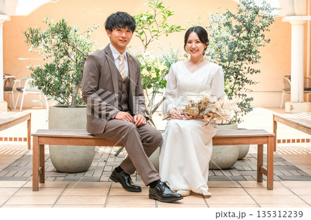 椅子に座るドレスのカップル,夫婦,新郎新婦,ドレスアップした夫婦,富豪,富裕層 135312239
