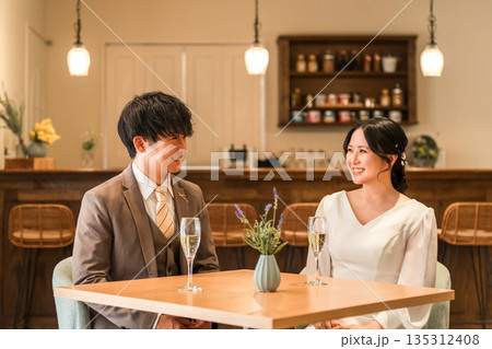 レストラン,バーでシャンパンを飲みながら会話するドレスコード姿のカップル,夫婦 レストラン,バーでシャンパンを飲みながら会話するドレスコード姿のカップル,夫婦 135312408