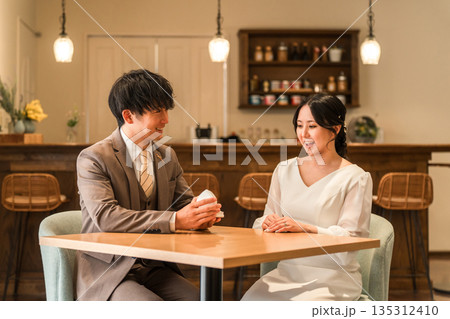 レストランでプロポーズをする男性と指輪を受け取る女性 レストランでプロポーズをする男性と指輪を受け取る女性 135312410