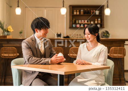 レストランでプロポーズをする男性と指輪を受け取る女性 レストランでプロポーズをする男性と指輪を受け取る女性 135312411