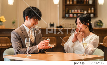 レストランでサプライズでプロポーズをする男性と驚く女性 レストランでサプライズでプロポーズをする男性と驚く女性 135312417
