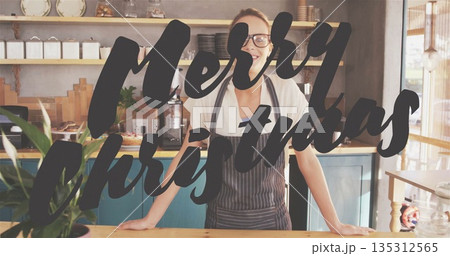 Barista in apron making espresso at wooden counter, with Christmas sign and pastries Barista in apron making espresso at wooden counter, with Christmas sign and pastries 135312565