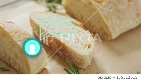 Displaying crusty bread slice on parchment on wooden countertop, with rosemary and turquoise icon 135312615