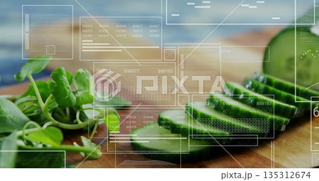 Showing sliced cucumber and watercress on wood cutting board on counter, with digital data overlays 135312674