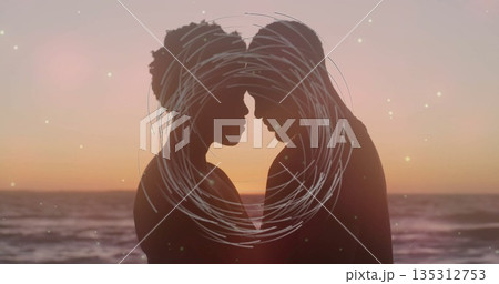 Leaning couple touching foreheads on beach at sunset, with circular scribble overlay and waves Leaning couple touching foreheads on beach at sunset, with circular scribble overlay and waves 135312753